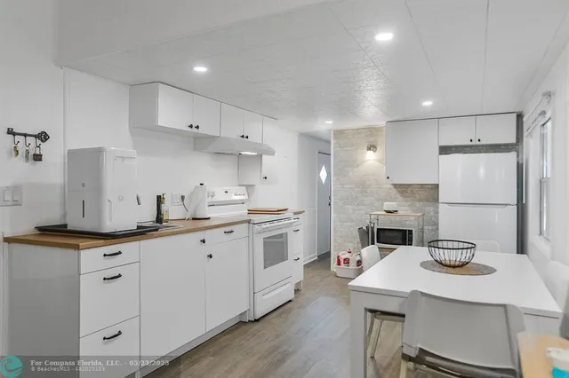 a kitchen with white cabinets sink and white stainless steel appliances