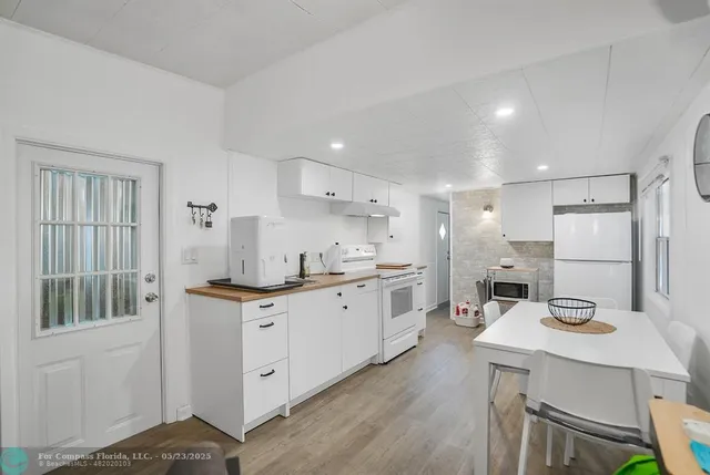 a kitchen with white cabinets and sink