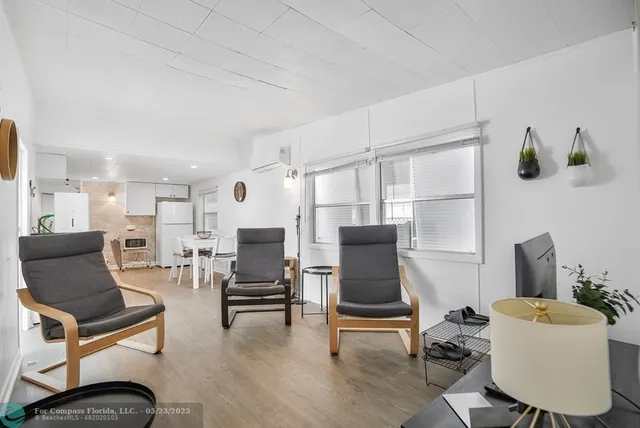a living room with furniture a flat screen tv and chairs