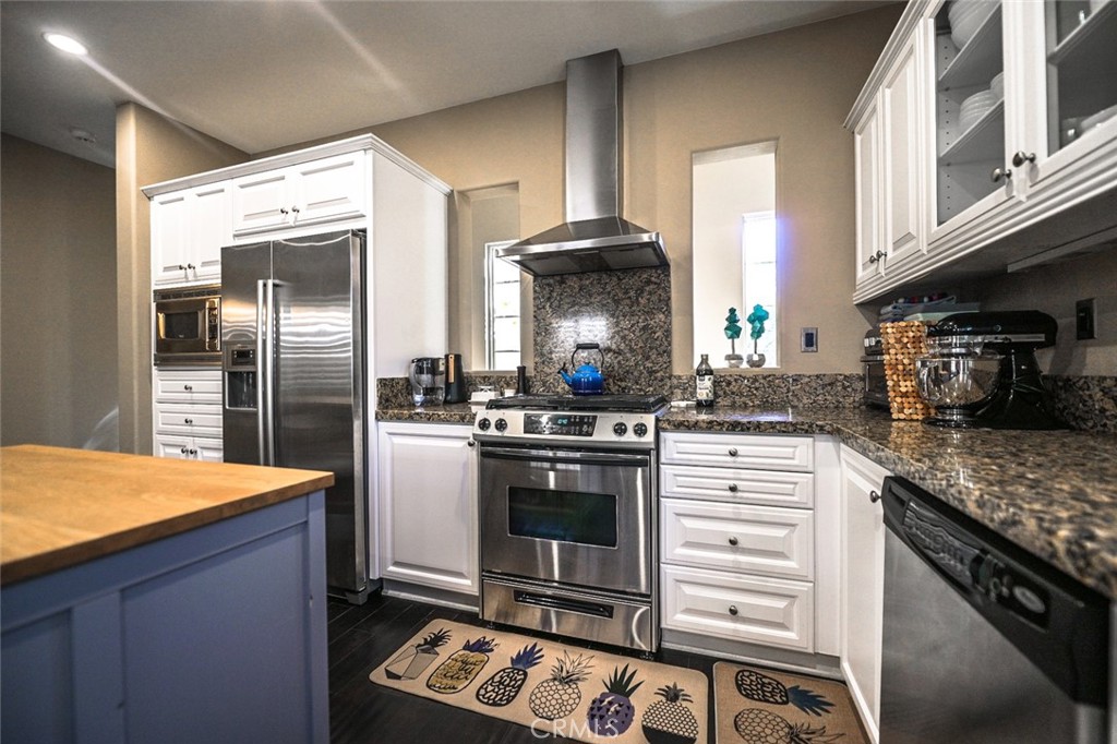 64 Scarlet Bloom Irvine, CA 92618 - Photo 7 of 22 a kitchen with stainless steel appliances granite countertop a stove a refrigerator and a sink