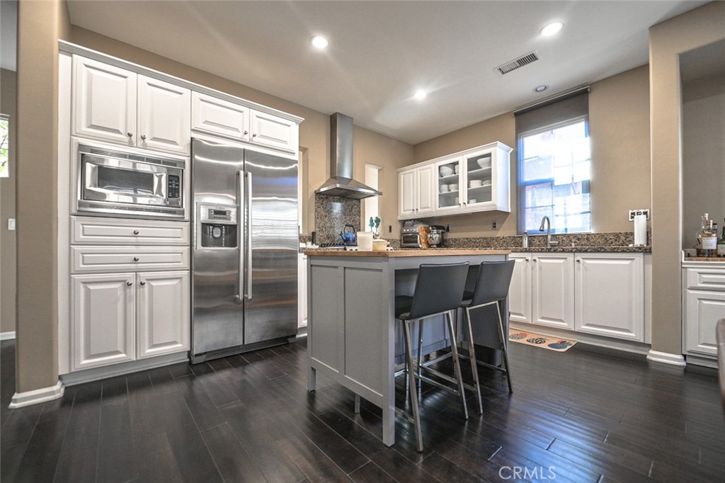 64 Scarlet Bloom Irvine, CA 92618 - Photo 9 of 22 a kitchen with stainless steel appliances granite countertop a table chairs refrigerator and sink
