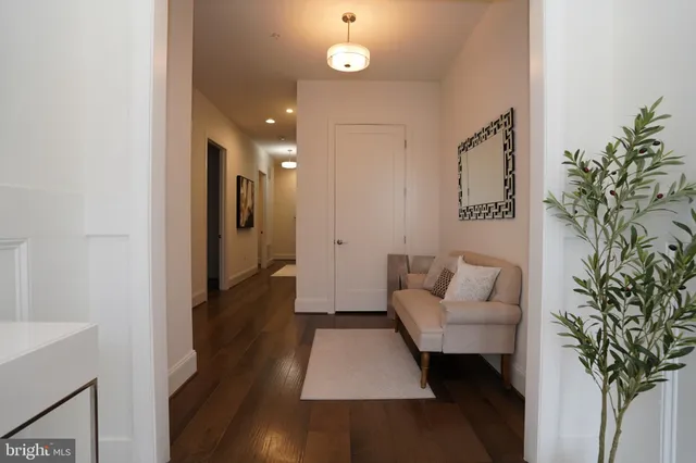 a view of a hallway with bathroom and wooden floor