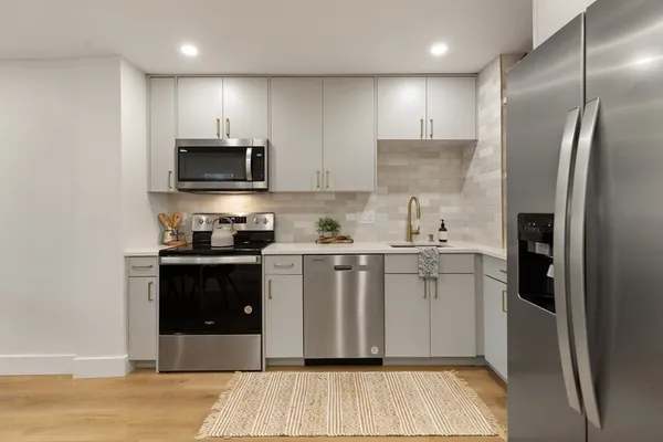 a kitchen with stainless steel appliances a refrigerator sink and microwave