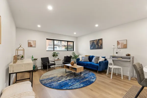 a living room with furniture and a wooden floor