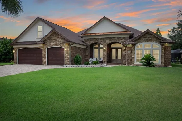a front view of a house with a garden and plants