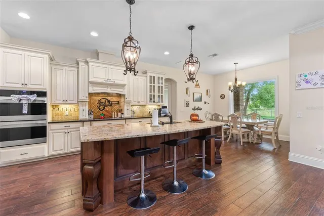 a view of a dining room and livingroom with furniture wooden floor and a large window