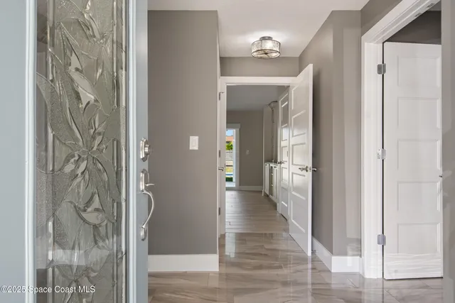 a view of a hallway with wooden floor and a bathroom