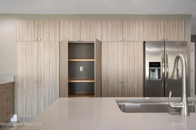 a view of a kitchen with refrigerator and a stove top oven