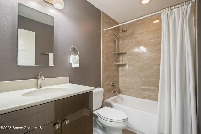 a view of an empty room with sliding glass door and a chandelier fan