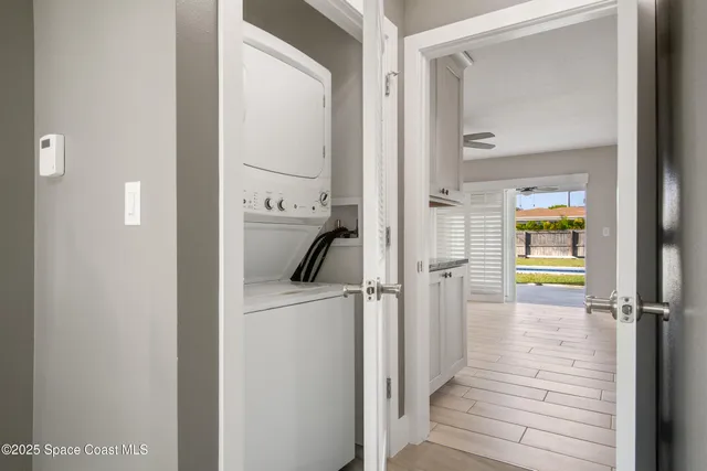 a view of an empty room with window and a ceiling fan
