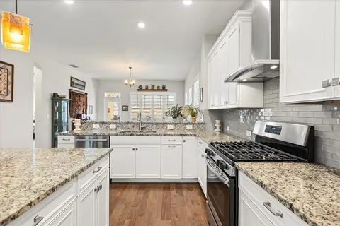 a kitchen with stainless steel appliances granite countertop a stove and a sink