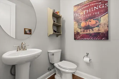 a bathroom with a toilet sink and mirror