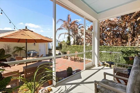 a view of a patio with a dining table and chairs under an umbrella