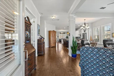 a view of a hallway with wooden floor and furniture