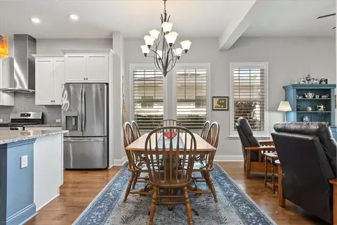 a kitchen with refrigerator a dining table and chairs