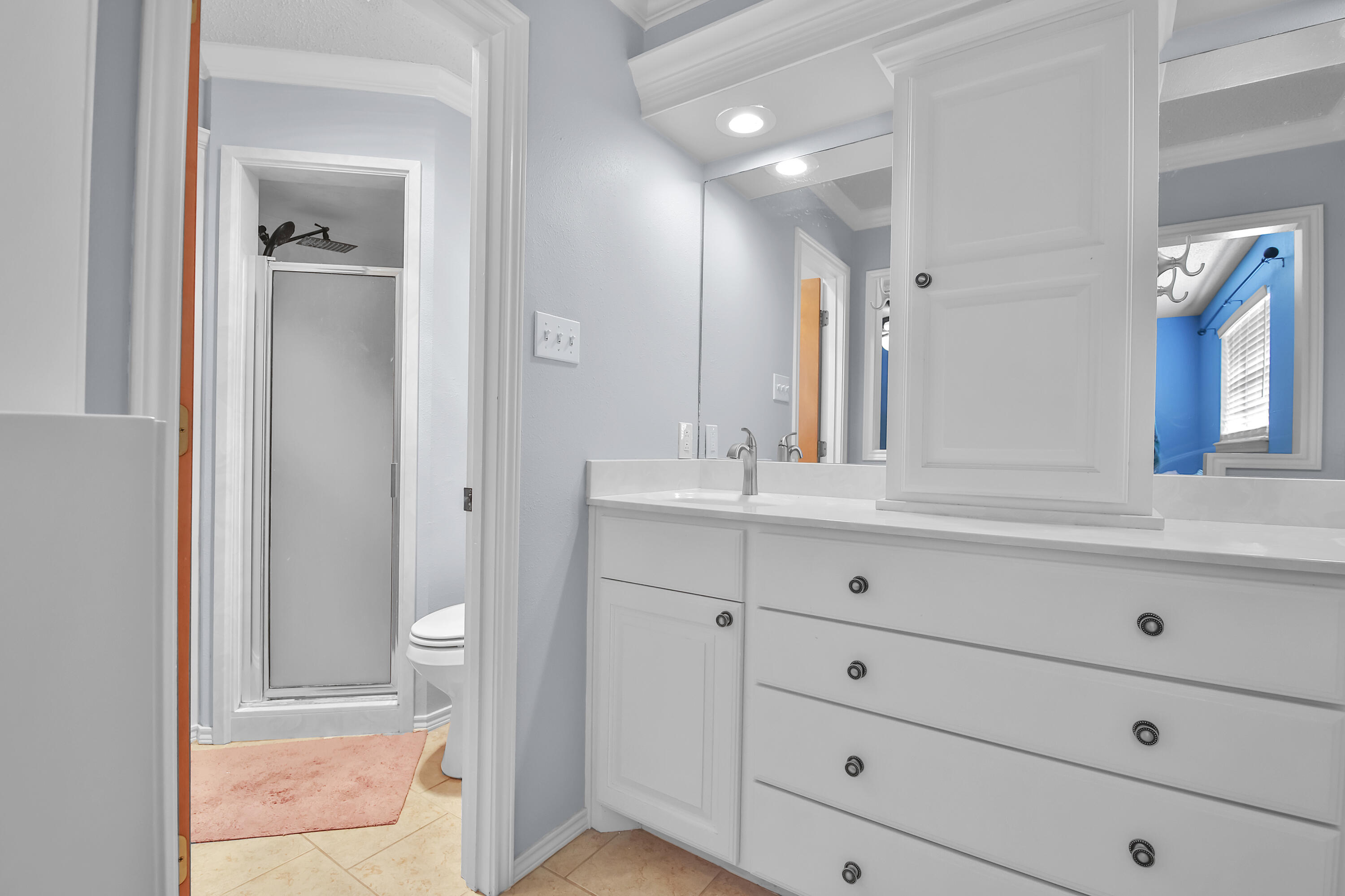 4805 73rd Street Lubbock, TX 79424 - Photo 16 of 26 a bathroom with a sink a toilet and large mirror
