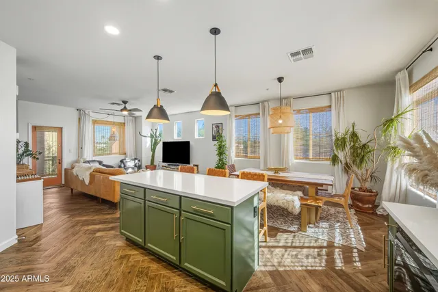 a room with lots of white furniture and a chandelier