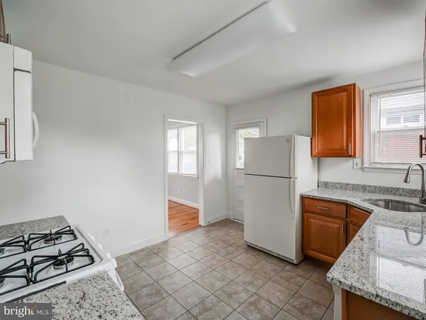a kitchen with a stove a refrigerator and cabinets
