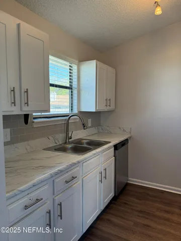 a kitchen with a sink cabinets and window