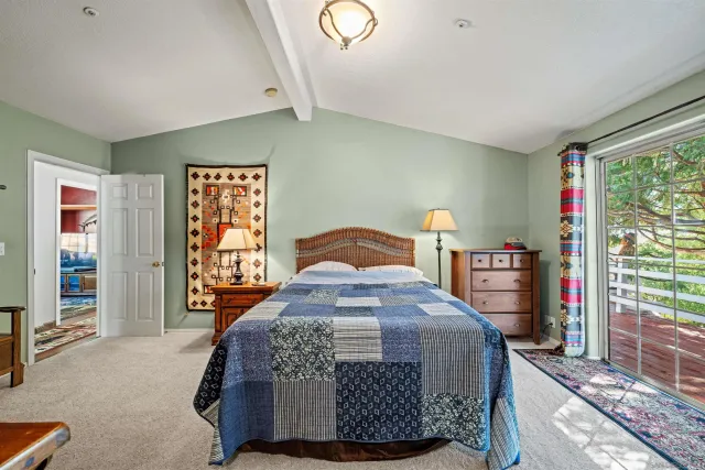 a bedroom with a bed and large windows