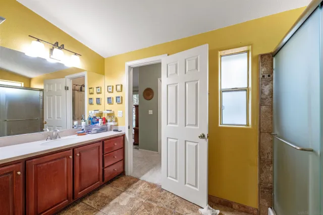 a spacious bathroom with a double vanity sink a mirror and a shower