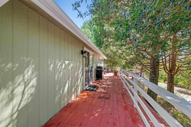 a view of wooden balcony and trees