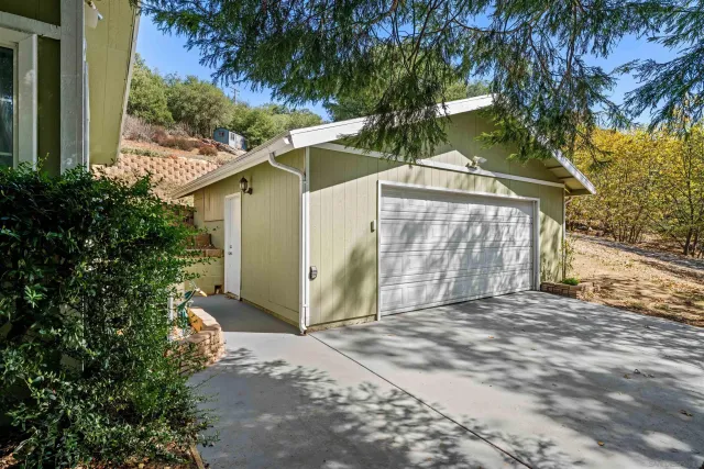 a white house that has tree in front of it