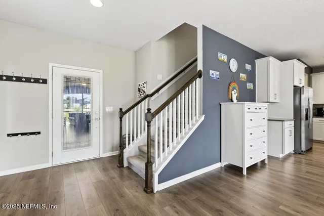 a kitchen with stainless steel appliances granite countertop a table chairs refrigerator and white cabinets
