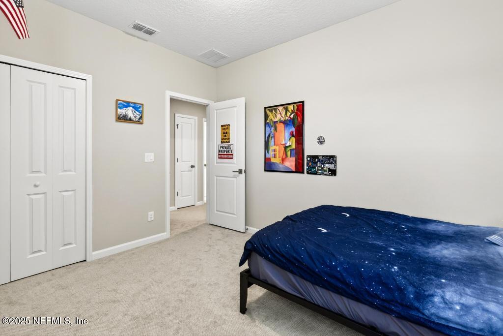 542 Silver Landing Drive St. Augustine, FL 32092 - Photo 46 of 55 a spacious bedroom with a bed and painting on the wall
