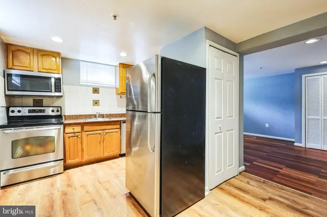 a kitchen with stainless steel appliances granite countertop a refrigerator and a stove top oven