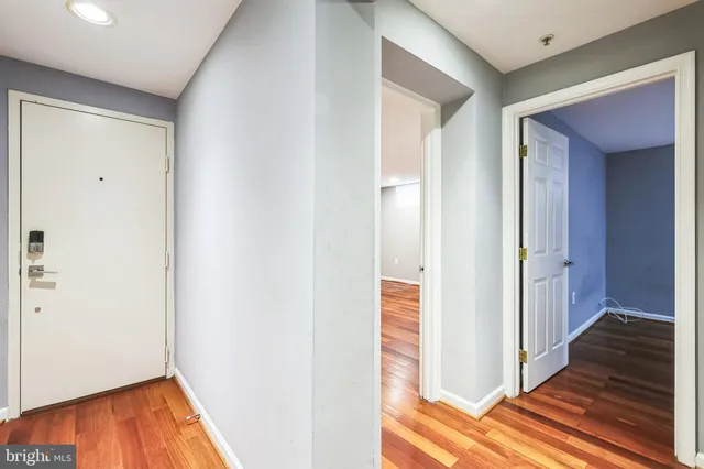 a view of a hallway with wooden floor and closet