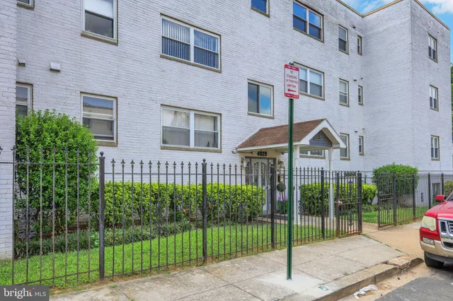 a view of a street in front of a brick house