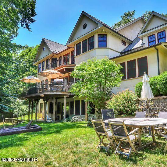 211 Orchard Street Cos Cob, CT 06830 - Photo 3 of 40 a front view of a house with a yard table and chairs