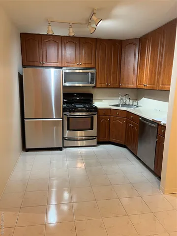 a kitchen with granite countertop a refrigerator and a stove top oven