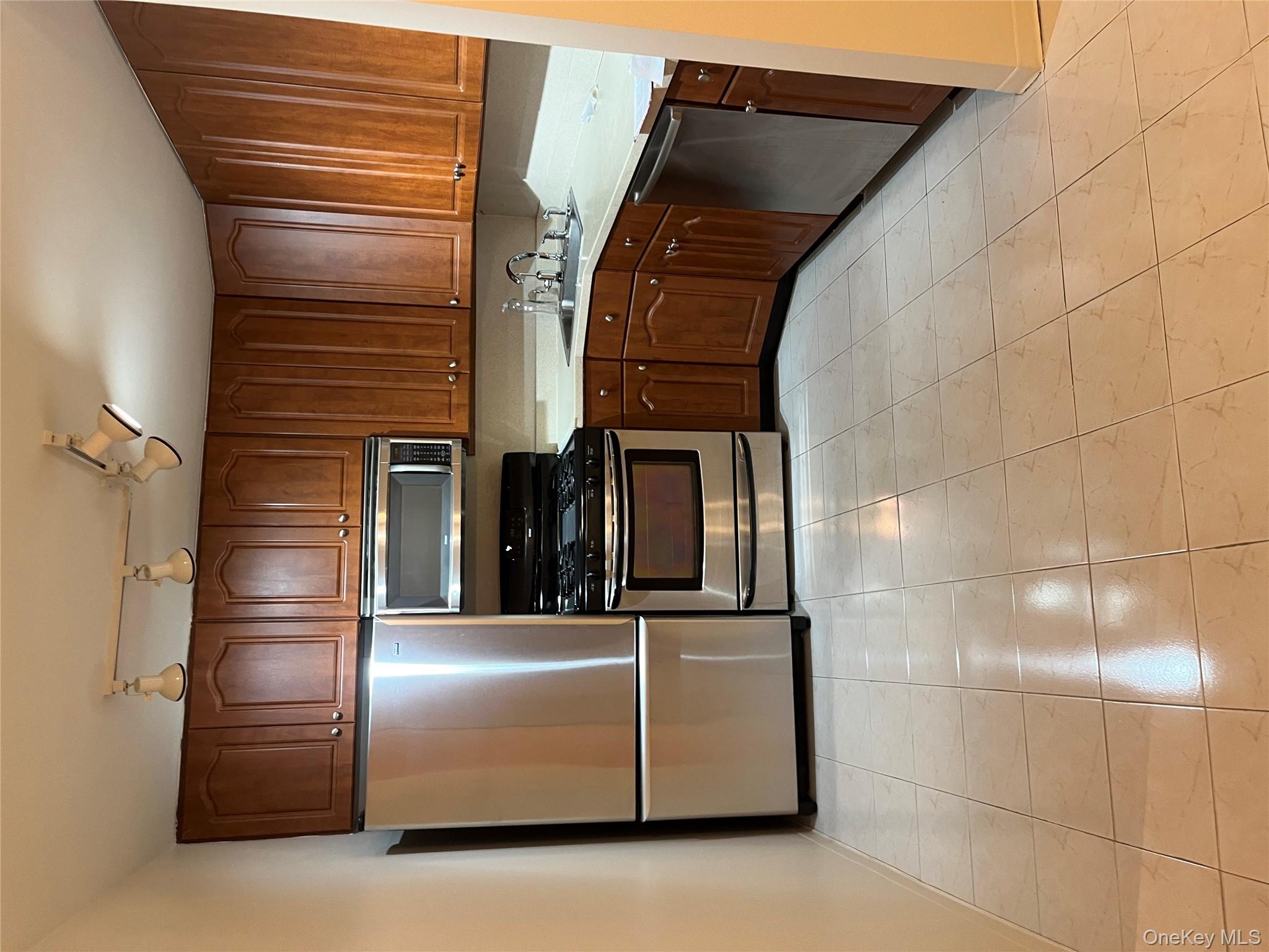 1 Bay Club Drive, Unit 6L Queens, NY 11360 - Photo 2 of 17 a kitchen with granite countertop a refrigerator and a stove top oven