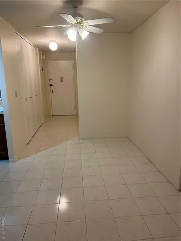 an empty room with fan and entrance