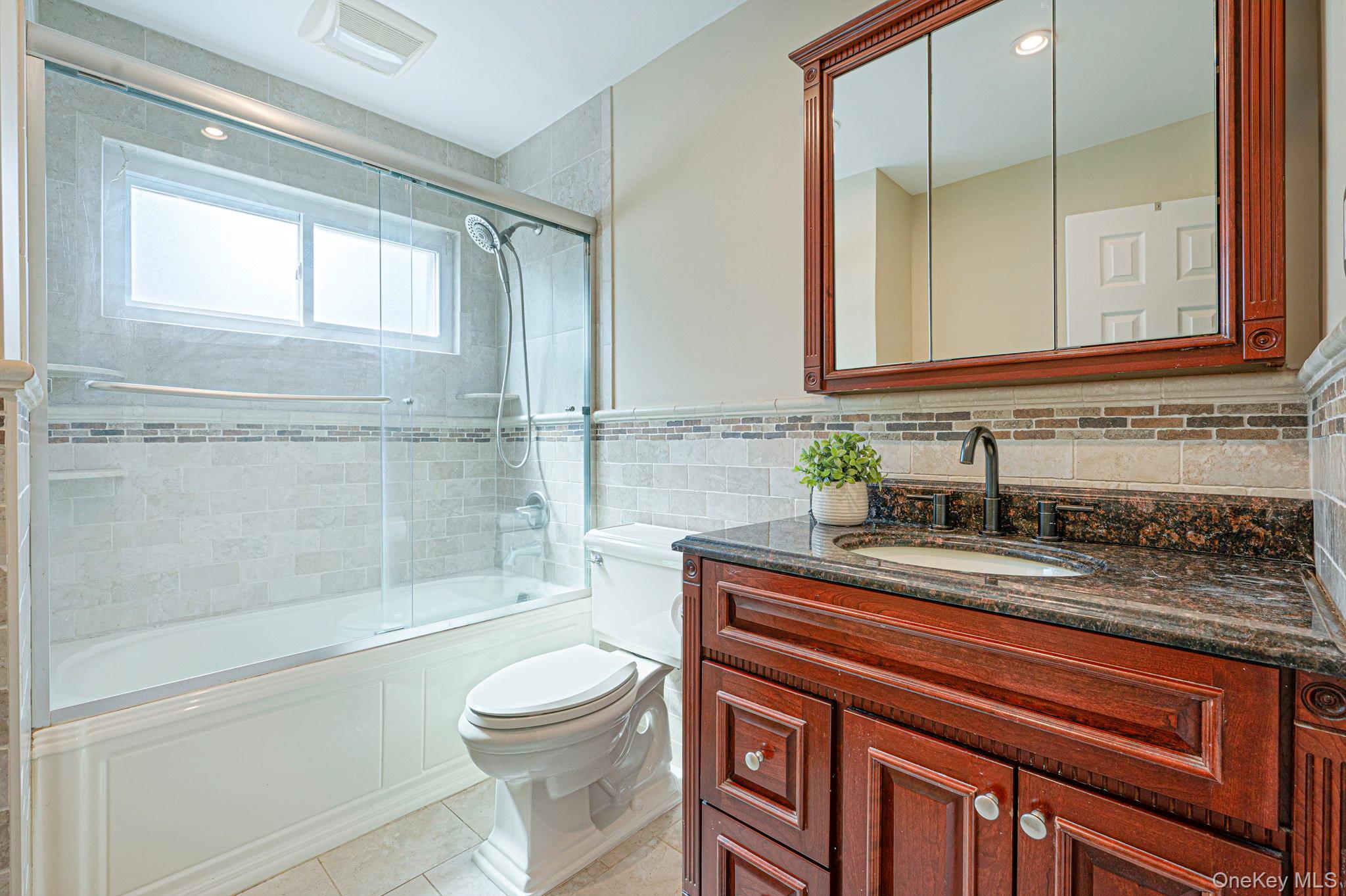 46 Sheldon Place Commack, NY 11725 - Photo 14 of 32 a bathroom with a granite countertop sink a toilet and shower