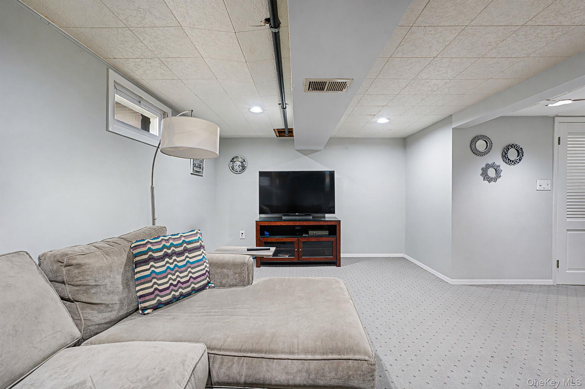 46 Sheldon Place Commack, NY 11725 - Photo 19 of 32 a living room with furniture and a flat screen tv