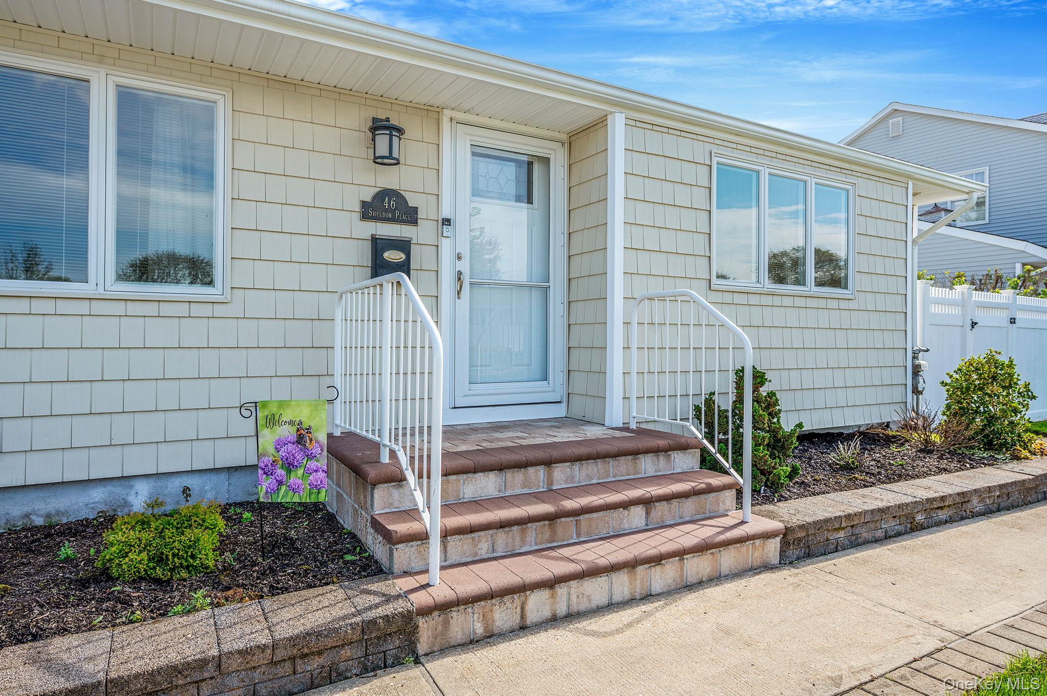 46 Sheldon Place Commack, NY 11725 - Photo 3 of 32 a front view of a house with a garden