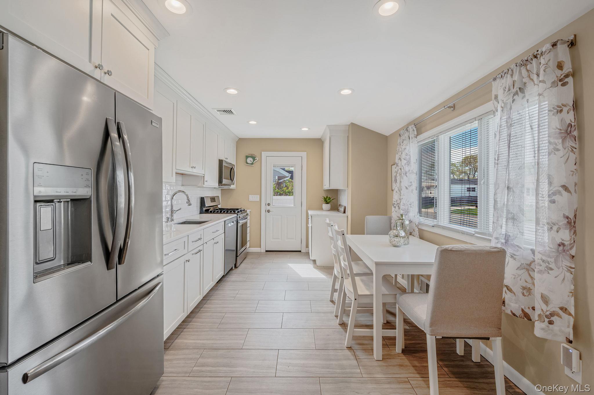 46 Sheldon Place Commack, NY 11725 - Photo 7 of 32 a large kitchen with a table and chairs