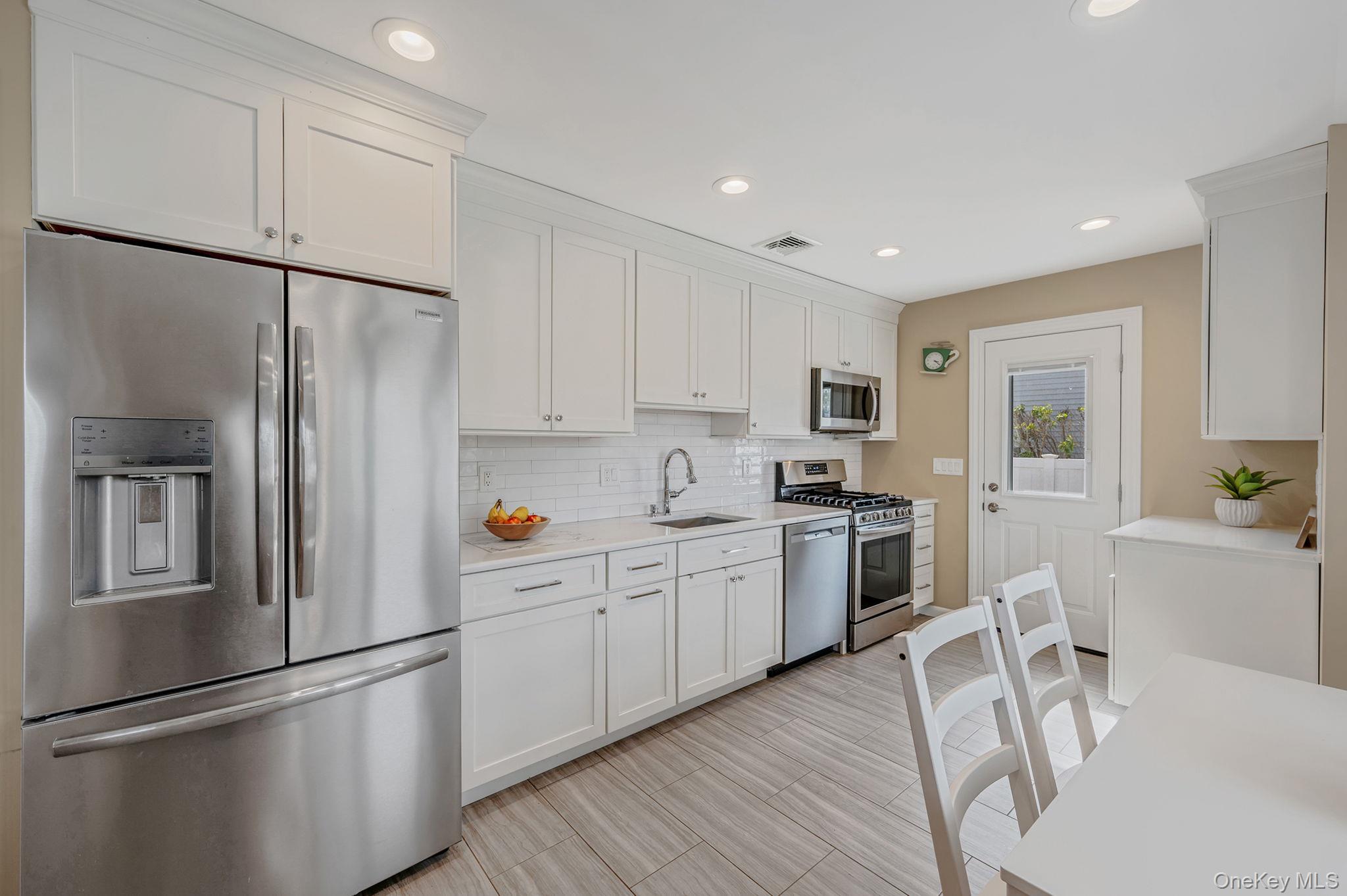46 Sheldon Place Commack, NY 11725 - Photo 8 of 32 a kitchen with white cabinets and stainless steel appliances