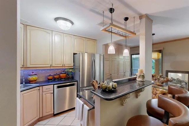 a very nice looking open dining room with kitchen island stainless steel appliances a table and chairs