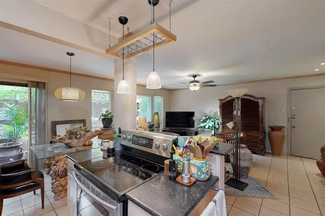 a kitchen with stainless steel appliances kitchen island granite countertop a sink a stove and a refrigerator