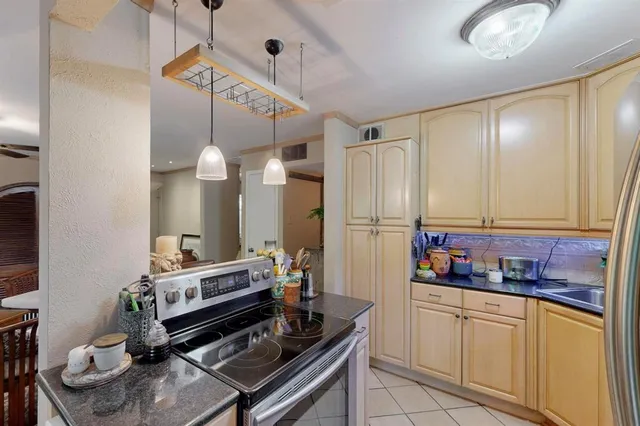 a kitchen with stainless steel appliances granite countertop a refrigerator and a wooden cabinets