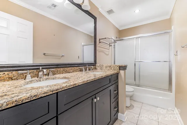 a spacious bathroom with a toilet sink and mirror
