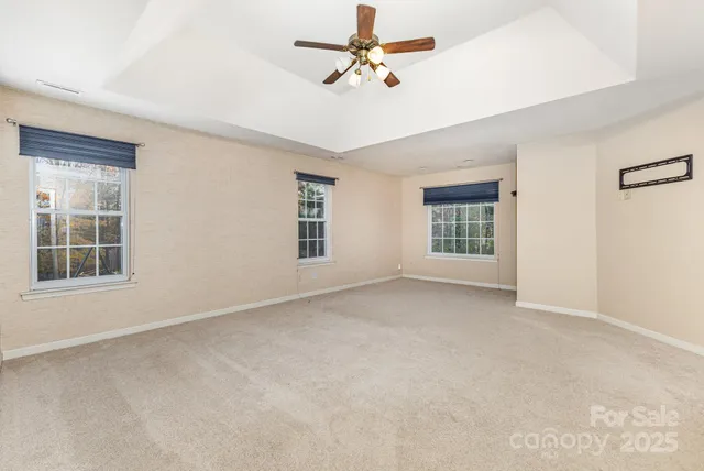 an empty room with a ceiling fan and a window
