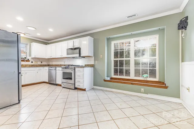 a kitchen with stainless steel appliances a stove microwave and cabinets