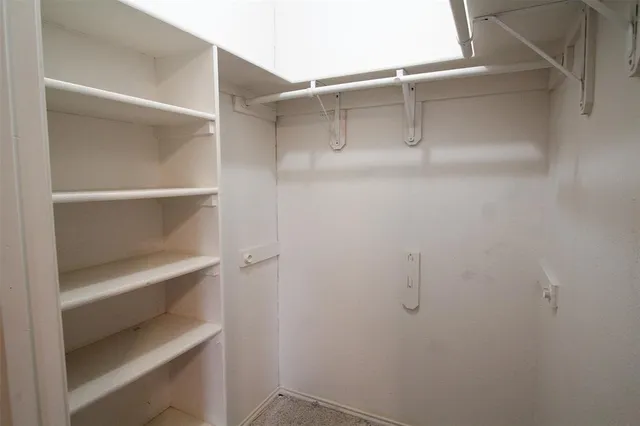 an empty room with a fireplace and large windows