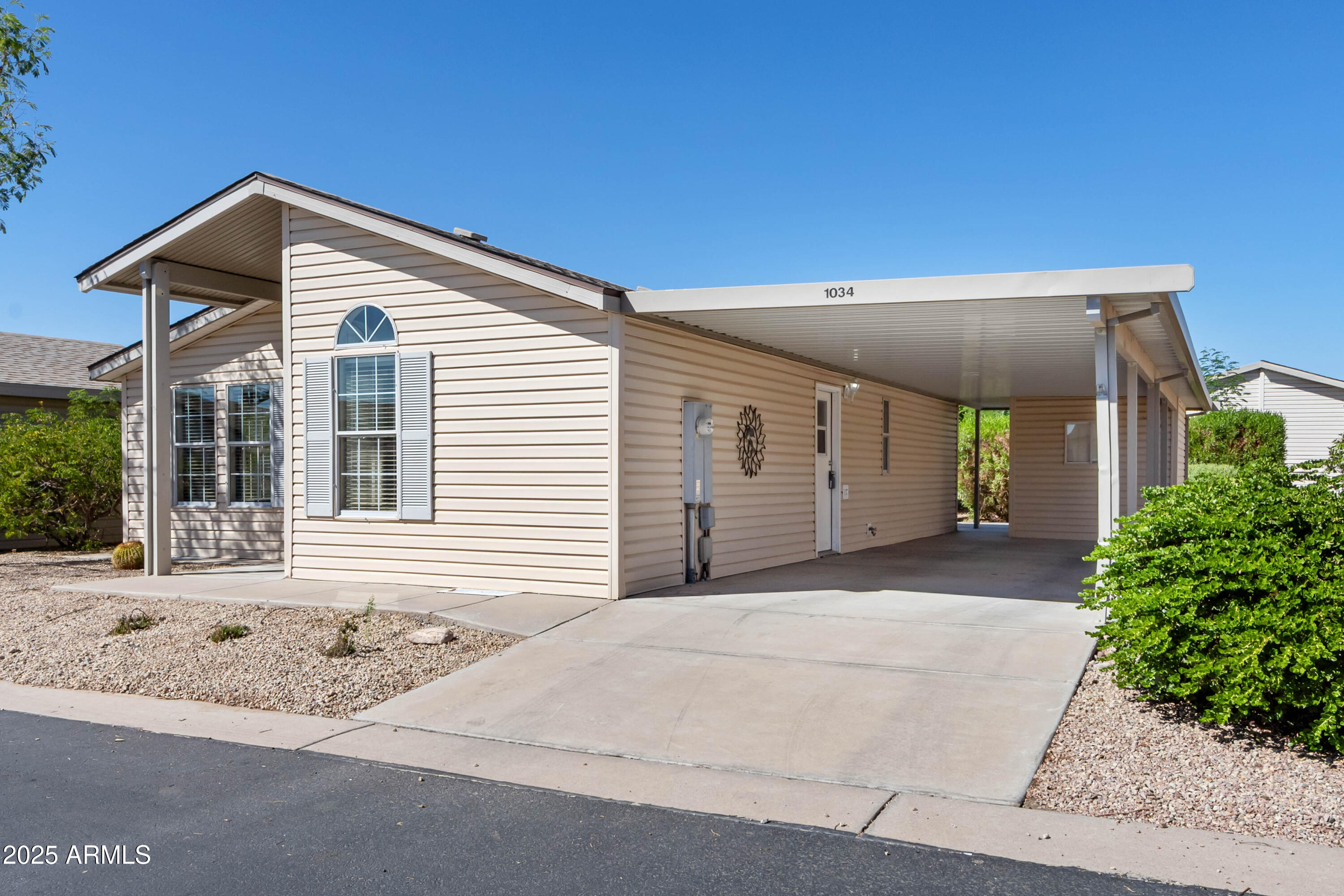 3301 South Goldfield Road, Unit 1034 Apache Junction, AZ 85119 - Photo 3 of 37 a front view of a house with a yard and garage