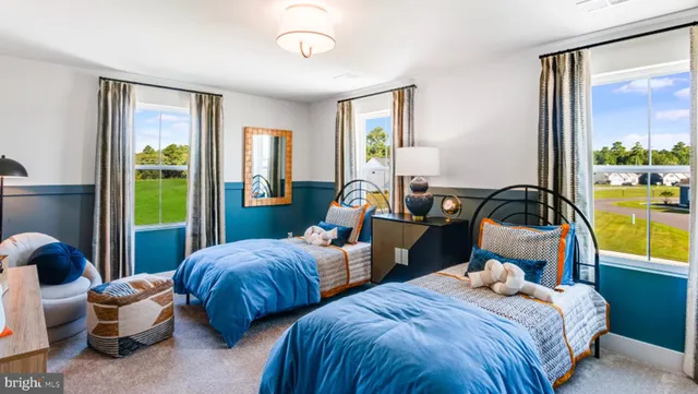 a bedroom with two beds and large windows